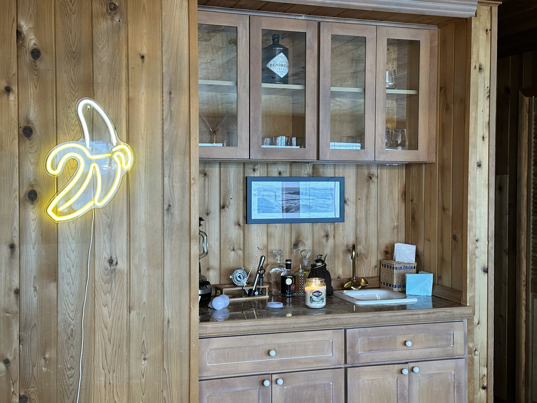 Bar area with Hendrick's gin display and neon banana sign