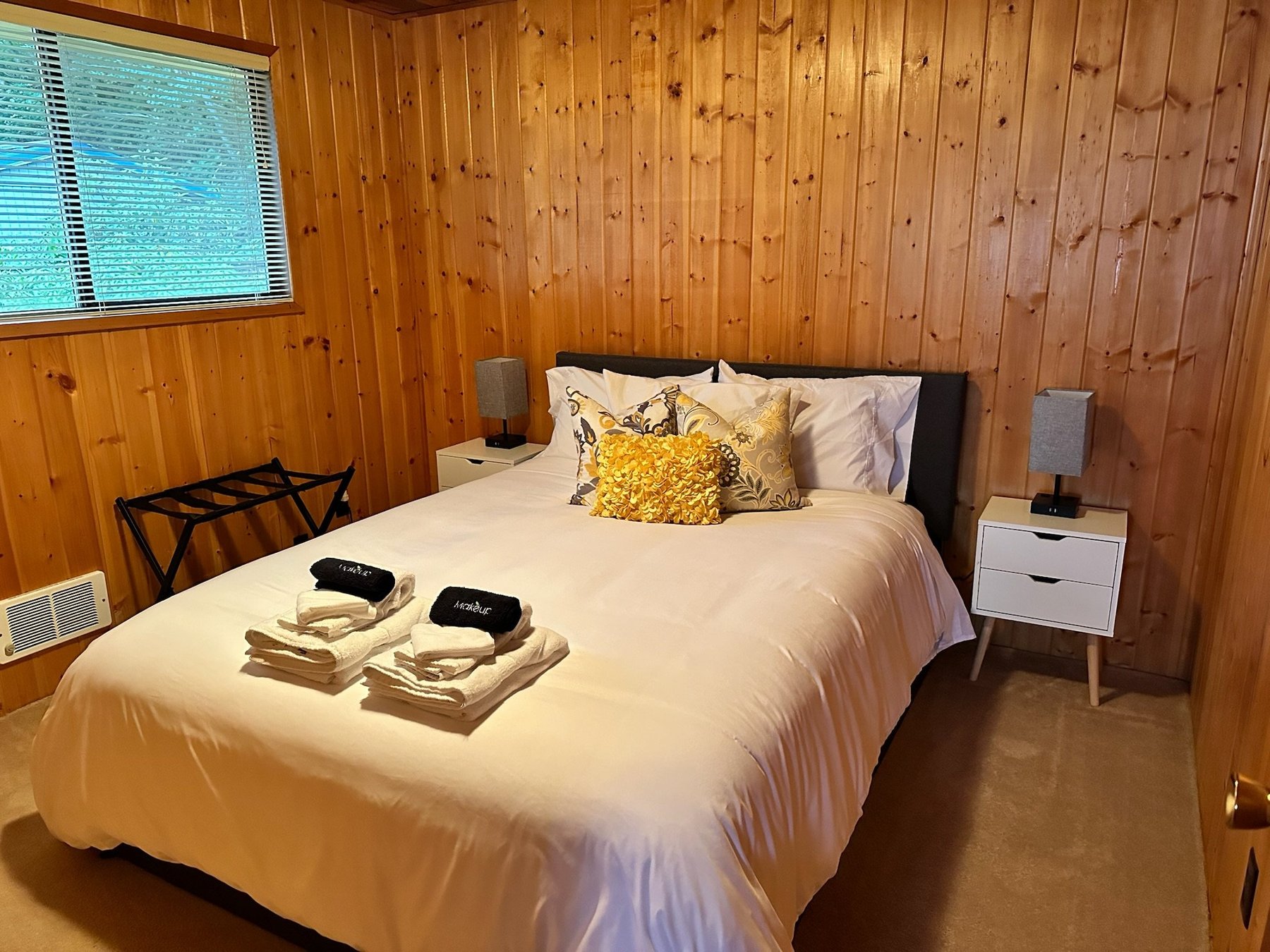 Bedroom with queen bed and yellow accent pillow