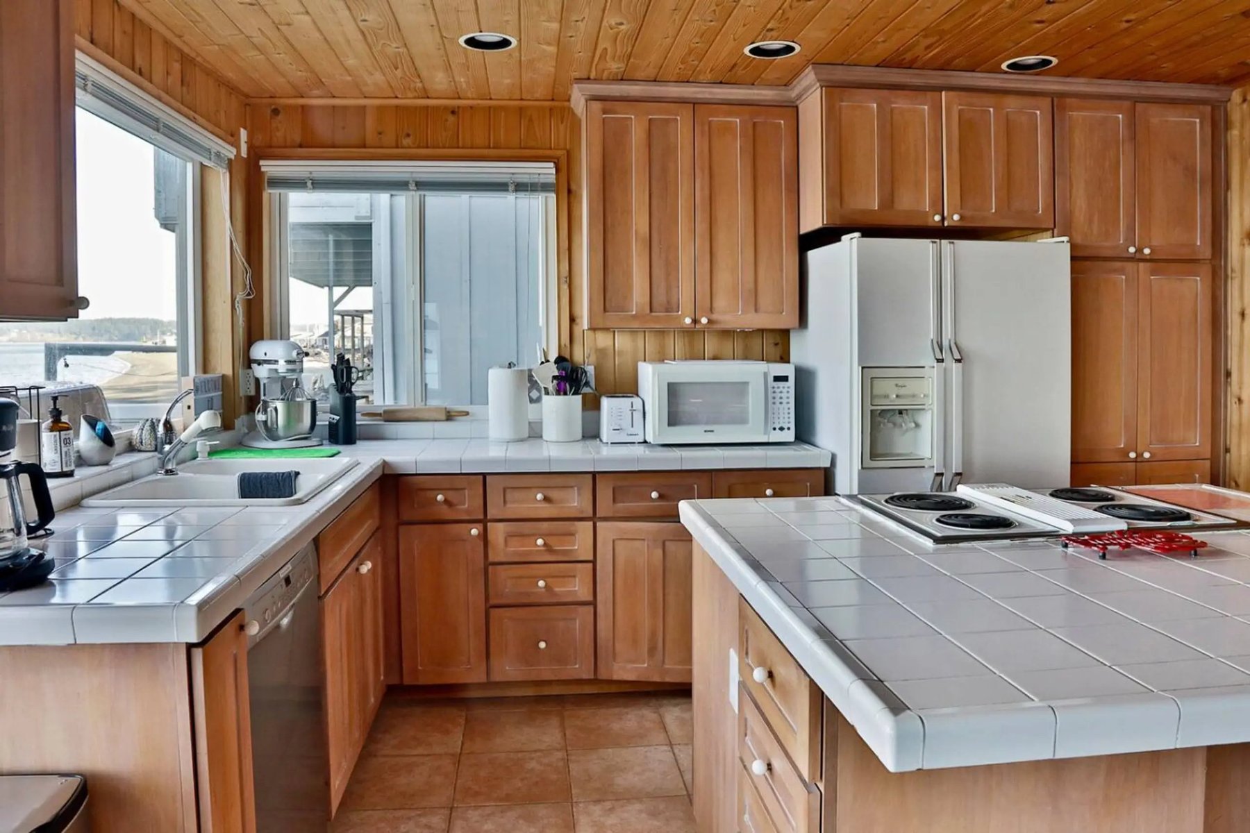 Kitchen with wood cabinets, tile counters, and water-view window