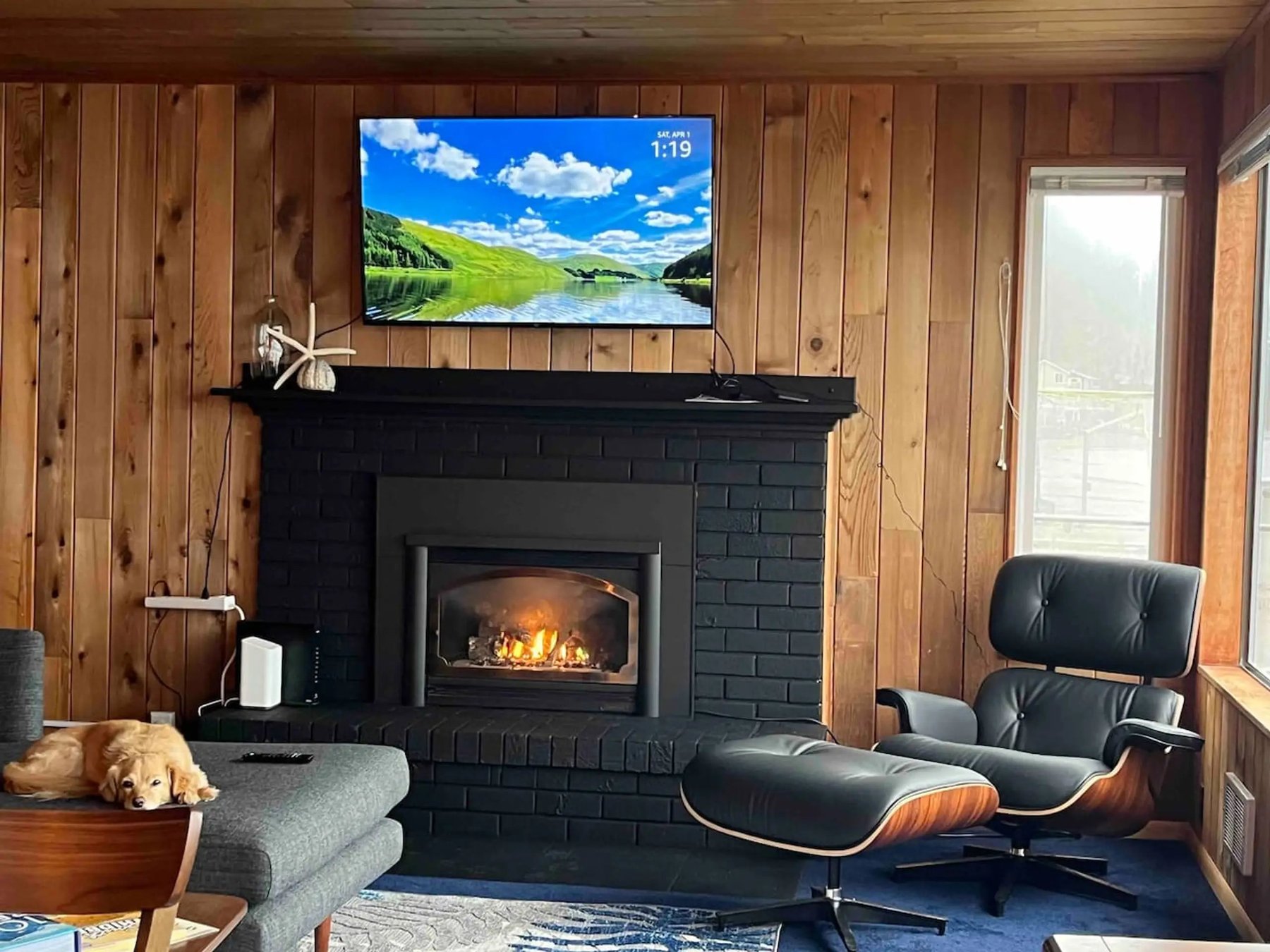 Living room with black brick fireplace and Eames chair